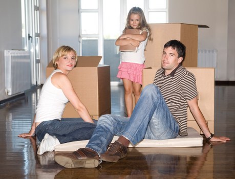 Piano movers transporting a piano through a narrow residential staircase